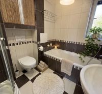 Das Badezimmer in der 3-Zimmer-Wohnung enthält eine Dusche, eine Badewanne und ein Waschbecken.