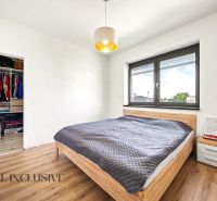 Schlafzimmer in einem Einfamilienhaus mit großem Bett, Schrank und Boden mit Holzdekor.