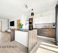 Küche in einem Einfamilienhaus mit Holzboden und weißen Schränken.