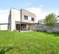 Ein Einfamilienhaus in Hrubá Borša mit Garten und Terrasse, umgeben von einer Hecke.