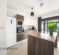 Eine Küche in einem Einfamilienhaus mit einem Holzboden und Glastüren zur Terrasse.