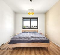 Helles Schlafzimmer mit Holzbett und Holzboden in einem Einfamilienhaus.