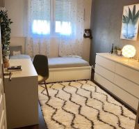Kinderzimmer mit Schreibtisch, Teppich und Boden mit Holzdekor in einem Einfamilienhaus.