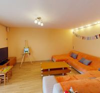 Wohnzimmer in einem Einfamilienhaus mit einem orangefarbenen Sofa, Holzboden.