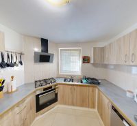 Küche im Einfamilienhaus mit Arbeitsplatten und Geräten, Holzmöbeldekor.