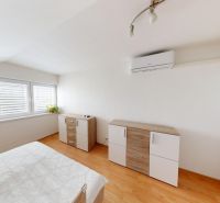 Helles Schlafzimmer mit Kommode und Holzboden in einem Einfamilienhaus.