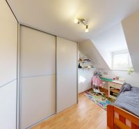 Kinderzimmer mit Holzboden, Einbauschrank und Schreibtisch in einem Einfamilienhaus.