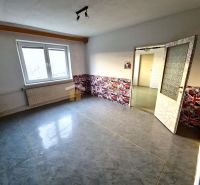 Ein Zimmer in einem Einfamilienhaus mit dekorierter Wand und großem Fenster, Boden mit Holzdekor.
