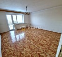 Ein Zimmer in einem Einfamilienhaus mit lackiertem Boden, weißen Wänden und einem Kronleuchter.