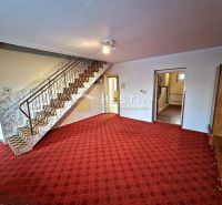 Treppe mit Teppich und offenen Türen in einem Einfamilienhaus.