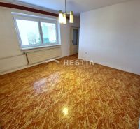Ein Zimmer in einem Einfamilienhaus mit einem Holzboden und einem großen Fenster.