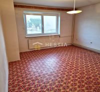 Ein Zimmer in einem Einfamilienhaus mit einem bunten geometrischen Teppich und weißen Wänden.