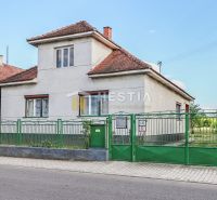 Ein Einfamilienhaus in Borský Mikuláš mit weißen Wänden und einem grünen Zaun.