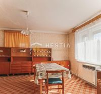 Innenraum eines Einfamilienhauses mit Esstisch, älteren Möbeln und Teppich.