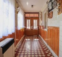 Flur in einem Einfamilienhaus mit gefliestem Boden und holzverkleideten Wänden.