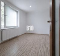 Ein leerer Raum mit Holzdekorboden in einer 3-Zimmer-Wohnung.