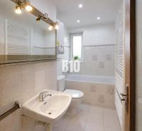 Badezimmer mit Badewanne, Waschbecken und Fenster in einer 3-Zimmer-Wohnung.