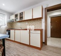Küche mit Holzboden in einer 3-Zimmer-Wohnung, ausgestattet mit hellen Möbeln.