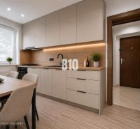Helle Küche mit Holzboden und einfachem Tisch in einer 3-Zimmer-Wohnung.