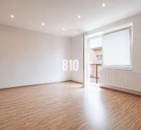 Ein geräumiges Zimmer in einer 3-Zimmer-Wohnung mit einem Holzboden und einem großen Fenster.