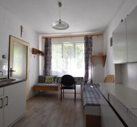 Einfache Küche mit Holzboden und Sofa in einem Einfamilienhaus.
