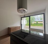 Küche in einer 2-Zimmer-Wohnung mit Holzboden und großen Fenstern.