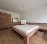 Schlafzimmer in einer 2-Zimmer-Wohnung mit Holzmöbeln und einem Boden mit Holzdekor.
