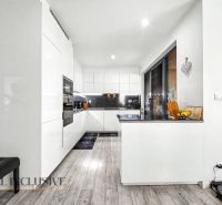 Küche in einer 3-Zimmer-Wohnung mit weißen Möbeln und einem Boden in Holzoptik.
