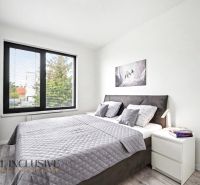 Schlafzimmer in einer 3-Zimmer-Wohnung mit Holzboden, großem Bett und Bild an der Wand.