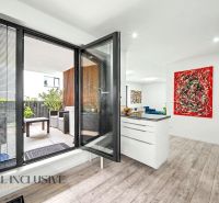Innenraum einer 3-Zimmer-Wohnung mit Balkon, Holzboden und farbenfroher Kunst.