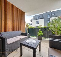 Balkon einer 3-Zimmer-Wohnung mit Rattanmöbeln und Pflanzen.