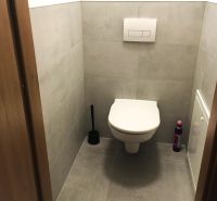 Badezimmer in einer 2-Zimmer-Wohnung mit Fliesen und einem hängenden WC.