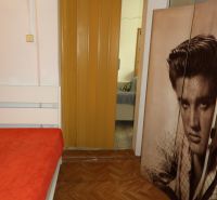 Ein Zimmer in einer 2-Zimmer-Wohnung mit einem Bett, einem Boden in Holzoptik und Schiebetüren.