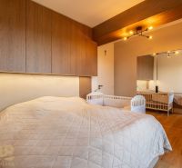 Schlafzimmer in einer 2-Zimmer-Wohnung mit Kinderbett und Holzboden.