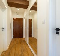 Der Flur in der 2-Zimmer-Wohnung mit einem Boden in Holzoptik und einem Spiegel an der Wand.