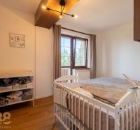 Schlafzimmer in einer 2-Zimmer-Wohnung mit Kinderbett und Holzboden.