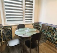 Essbereich in einer 4-Zimmer-Wohnung mit Blumen-Tapete und einem Tisch für vier Personen.