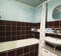 Badezimmer mit einer emaillierten Badewanne und gefliesten Wänden in einer 4-Zimmer-Wohnung.