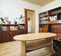 Wohnzimmer mit Schränken, Büchern, Blumen und einem Boden mit Holzdekor in einer 4-Zimmer-Wohnung.