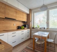 Küche mit Holzboden in einer 3-Zimmer-Wohnung, mit Esstisch am Fenster.