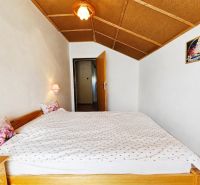 Schlafzimmer im Einfamilienhaus mit Doppelbett und Wandleuchten.