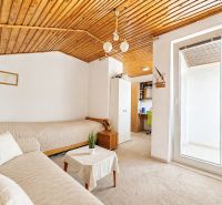Ein Zimmer in einem Einfamilienhaus mit einer Holzdecke, einem Sofa und einer Arbeitsecke.