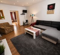 Wohnzimmer in einem Einfamilienhaus mit Holzboden und bequemen Sitzgelegenheiten.