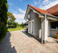 Ein Einfamilienhaus in Selice mit Terrassenfliesen, Garten und weißen französischen Fenstern.
