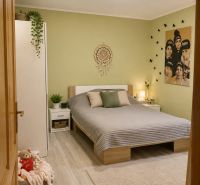 Schlafzimmer im Einfamilienhaus mit Bett, beigem Teppich und Wanddekoration.