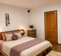 Schlafzimmer im Einfamilienhaus mit Palettenbett und Boden in Holzoptik.