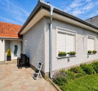 Ein Einfamilienhaus in Selice mit Blumen an den Fenstern und einem gepflasterten Hof.