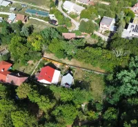 Luftaufnahme der Gärten in Kolačno mit verstreuten Häusern und üppigem Grün.