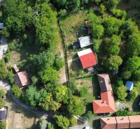 Luftaufnahme von Gärten und Häusern in Kolačno, umgeben von dichtem Grün.