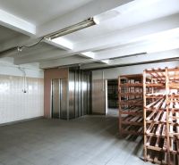 Produktionsräume mit Fliesenboden, Holzregalen und einem Aufzug.